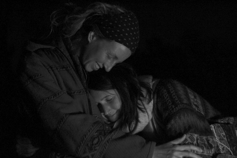 woman in black jacket kissing man in black jacket