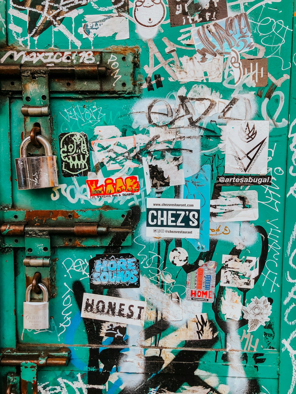 red metal padlock on green and white wooden door