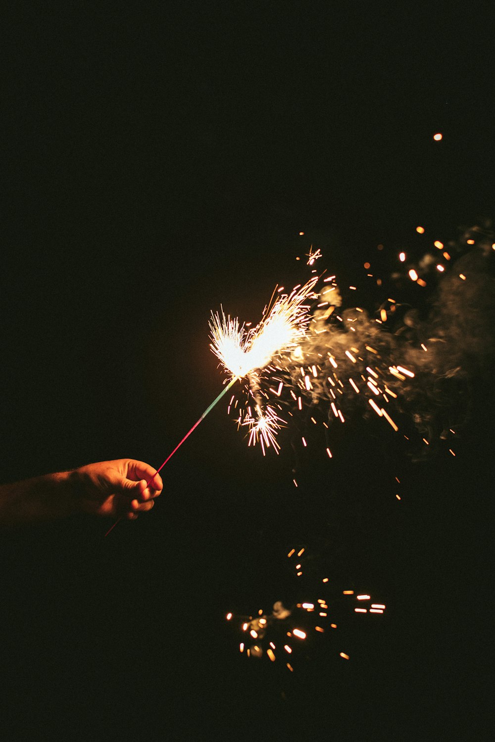 person holding sparkler during nighttime