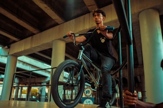 Close-up shot of Alexandre coaching a young BMX rider on technique.