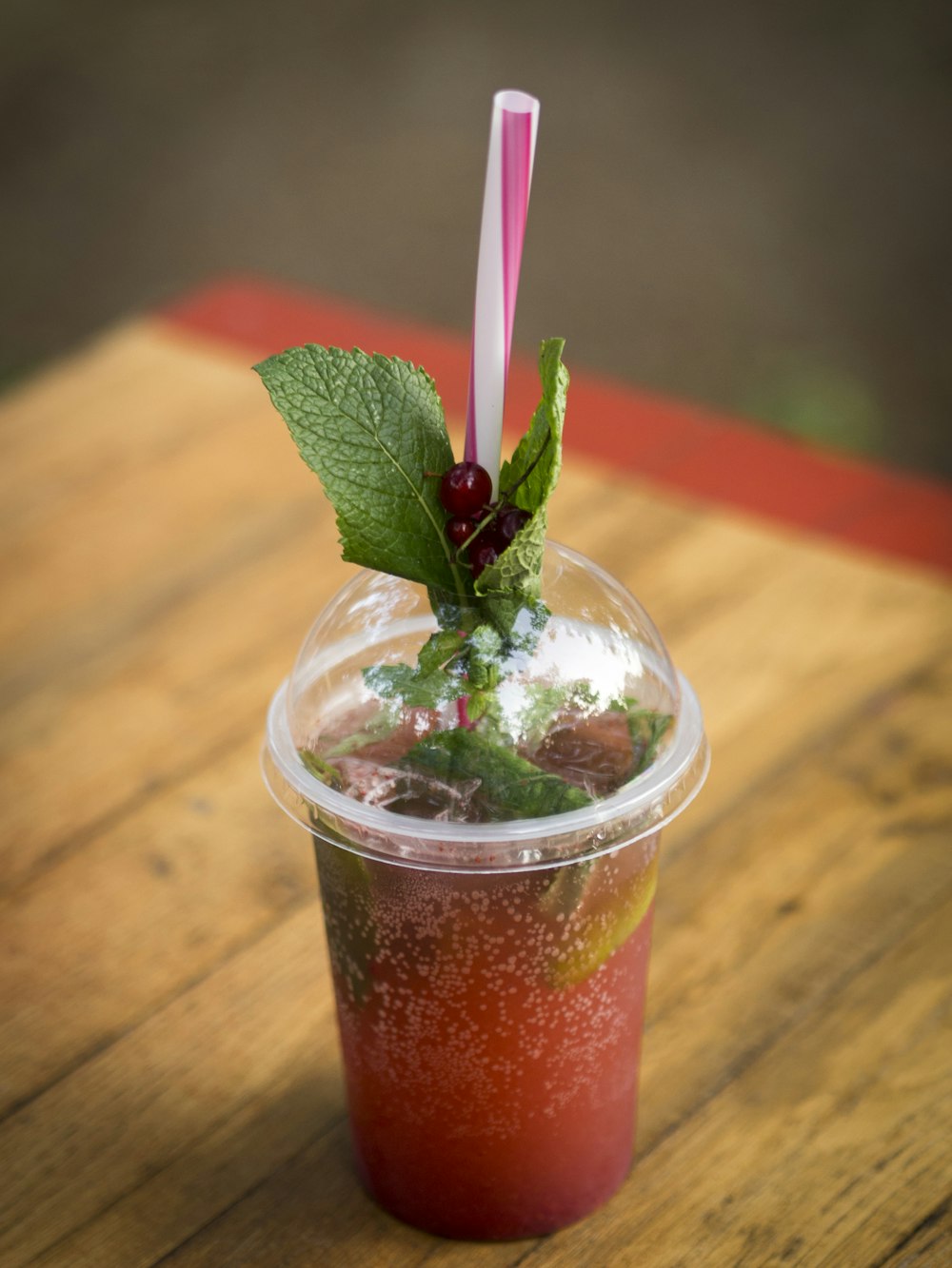 clear plastic cup with red liquid and ice