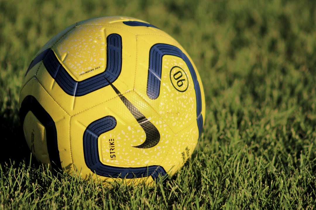 yellow and blue soccer ball on green grass field during daytime