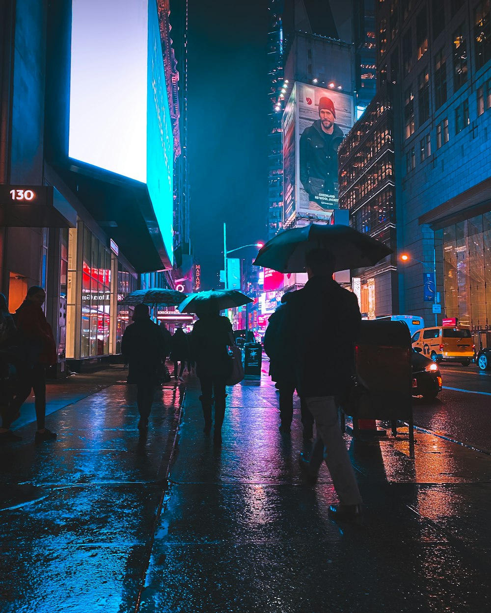 persone che camminano per strada durante la notte