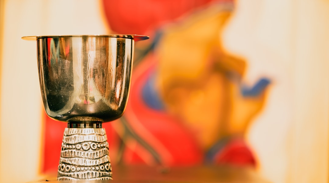 silver cup on brown wooden table