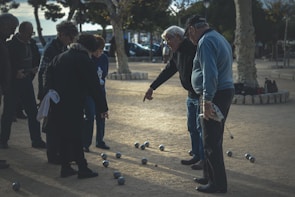 Smiling seniors playing bocce ball outdoors on a sunny day