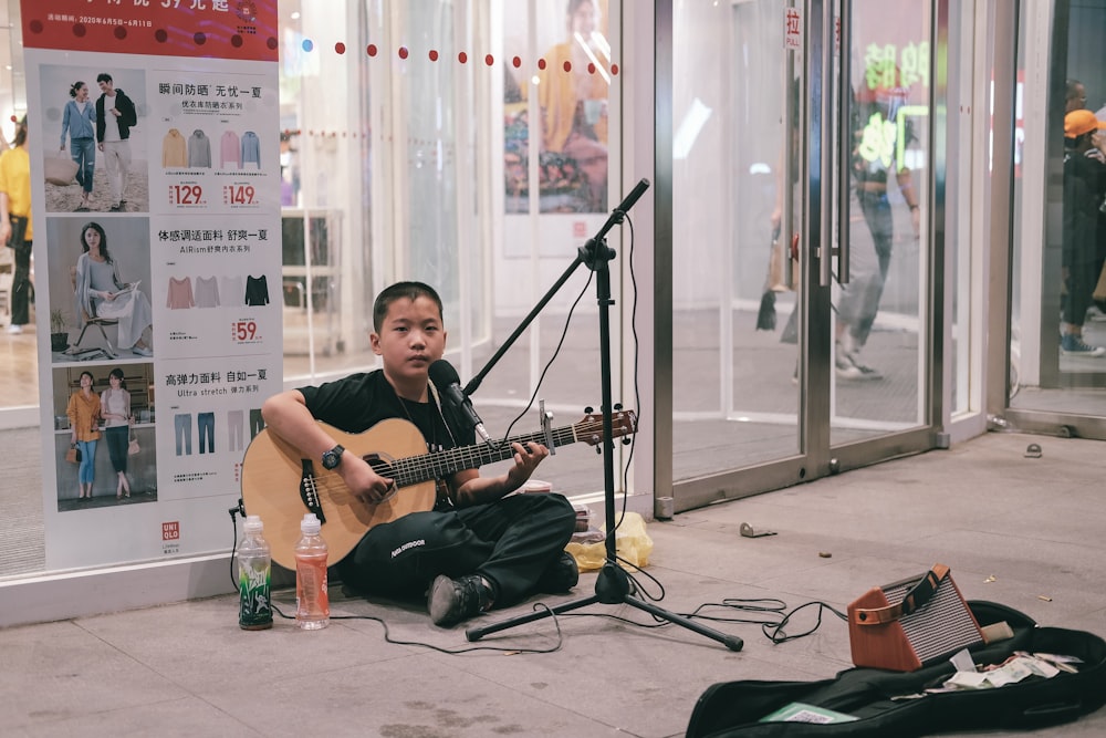 man in black t-shirt playing guitar