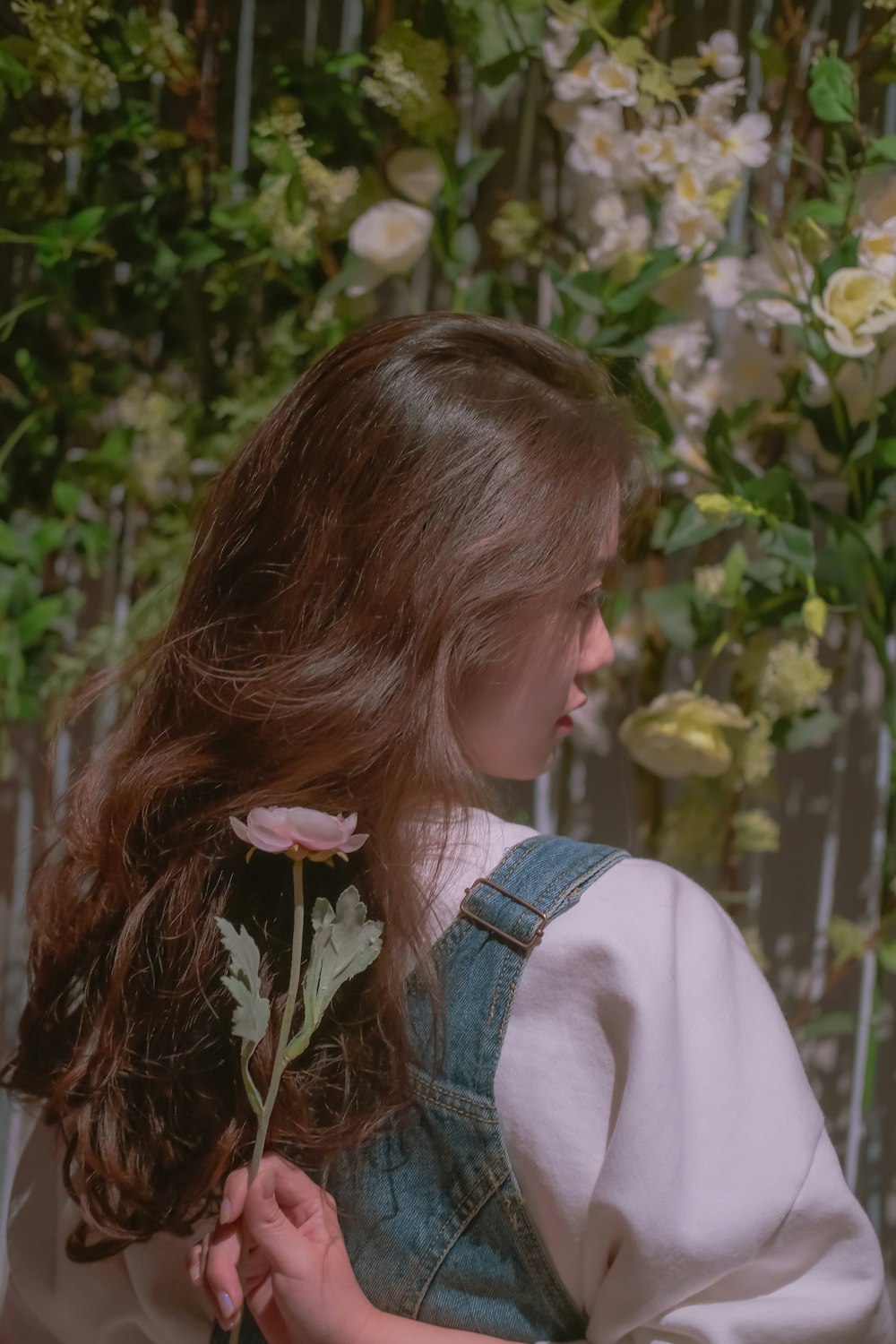 girl in white shirt holding white flower