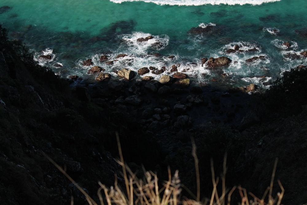 brown and black rocks on seashore during daytime