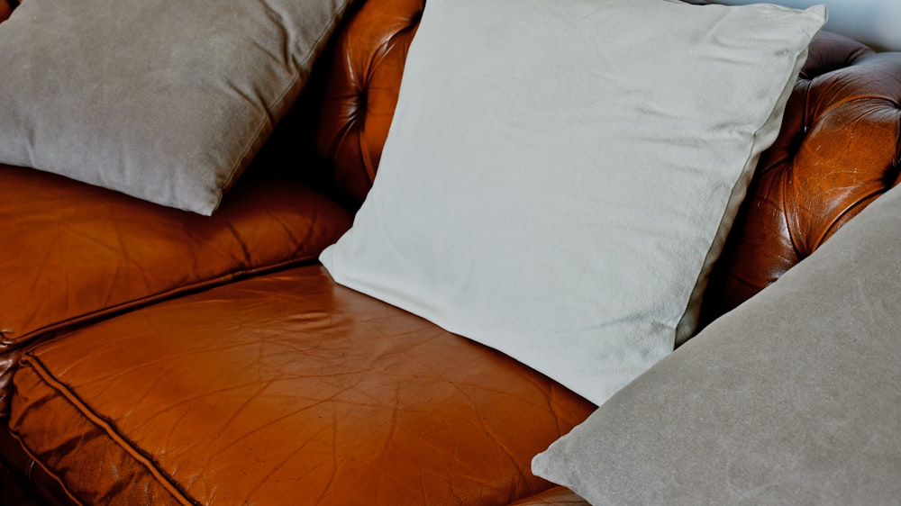 white pillow on brown leather couch