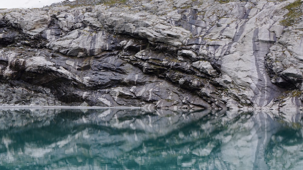 gray rock formation beside body of water during daytime