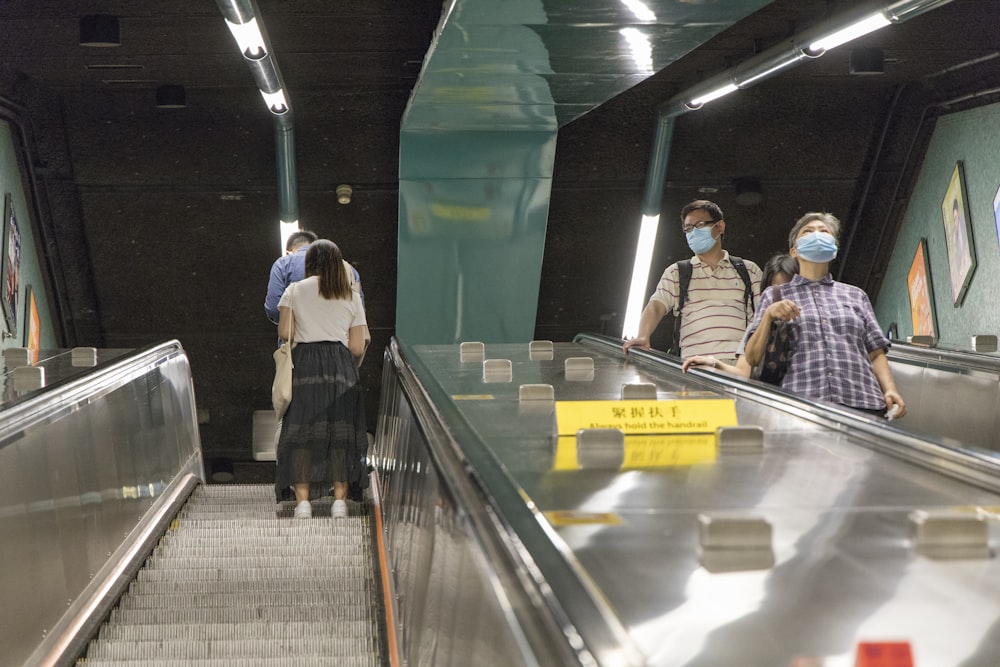 people walking on escalator inside building