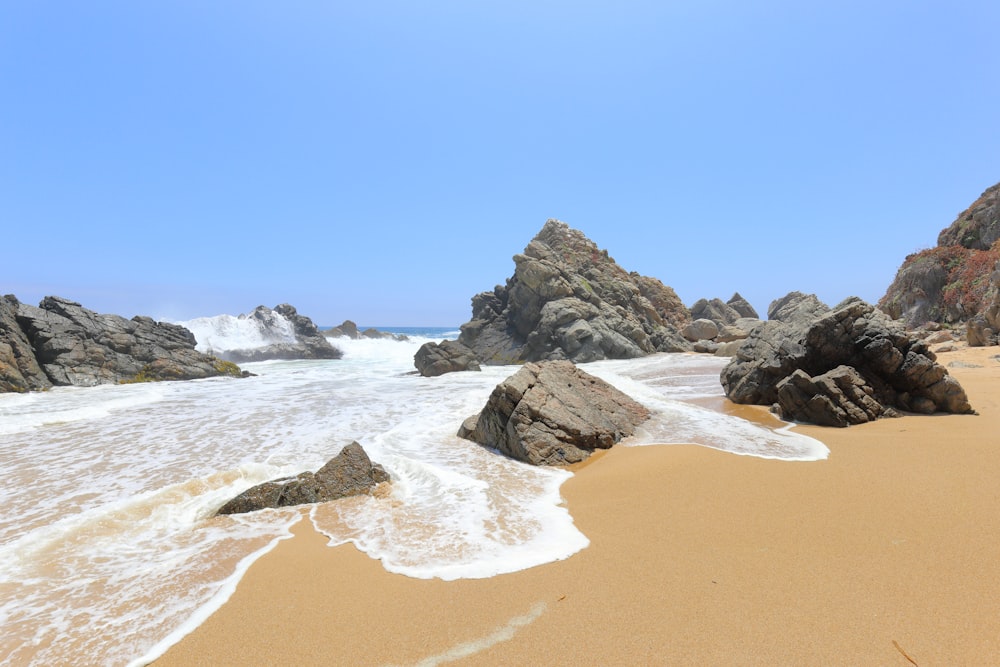 black rock formation on sea shore during daytime