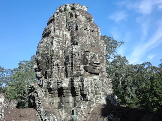 gray rock formation under blue sky during daytime in Angkor Thom Cambodia