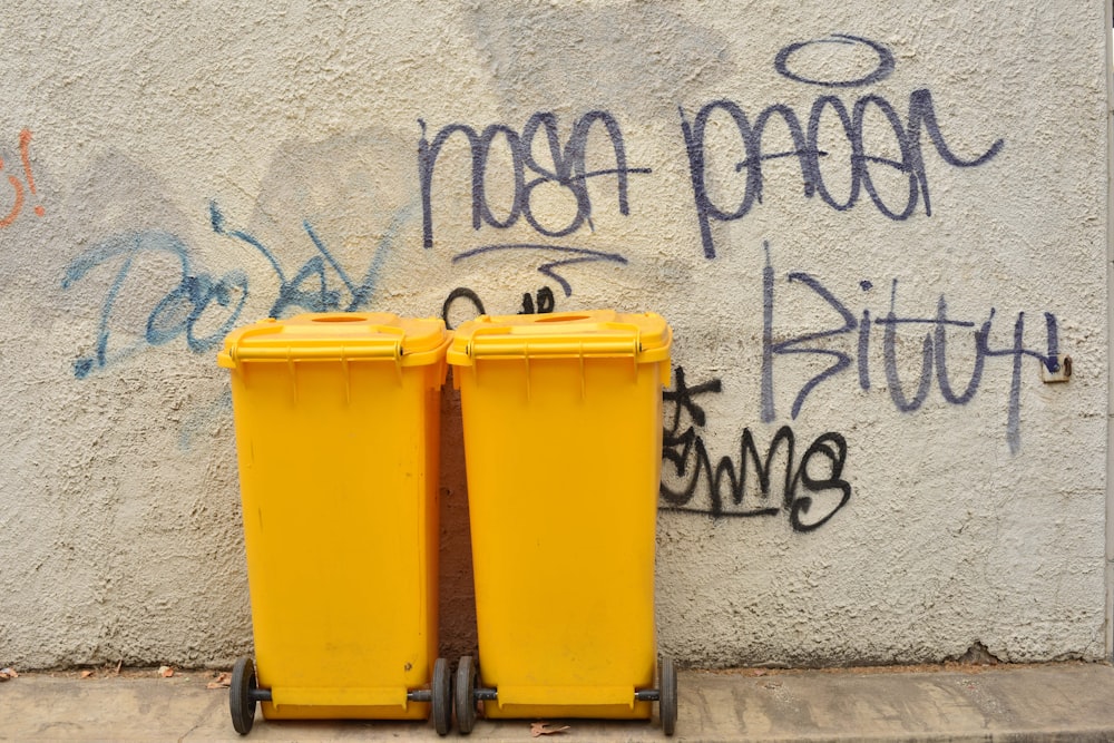 yellow trash bin beside white wall