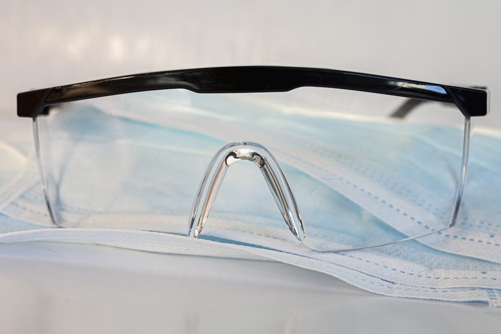 black framed eyeglasses on white textile