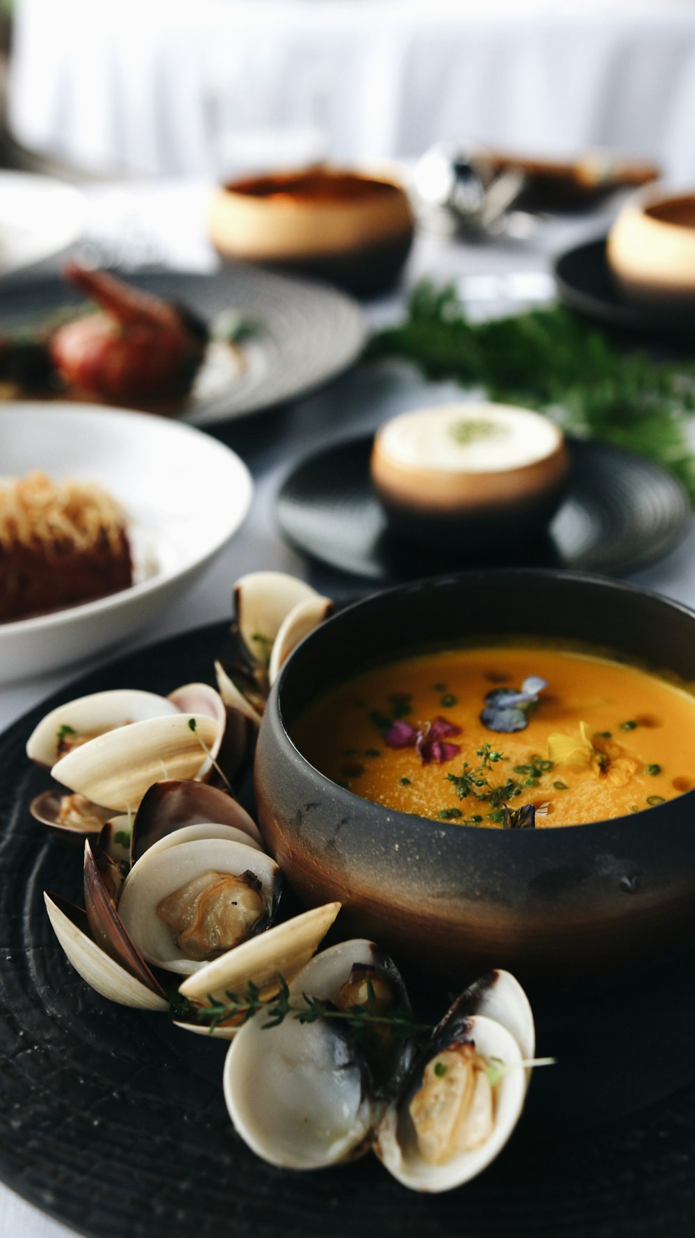 soup with sliced of meat on black ceramic bowl