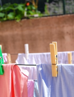 pink and white textiles hanged on brown wooden clothes hanger