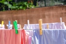 pink and white textiles hanged on brown wooden clothes hanger