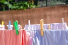 pink and white textiles hanged on brown wooden clothes hanger