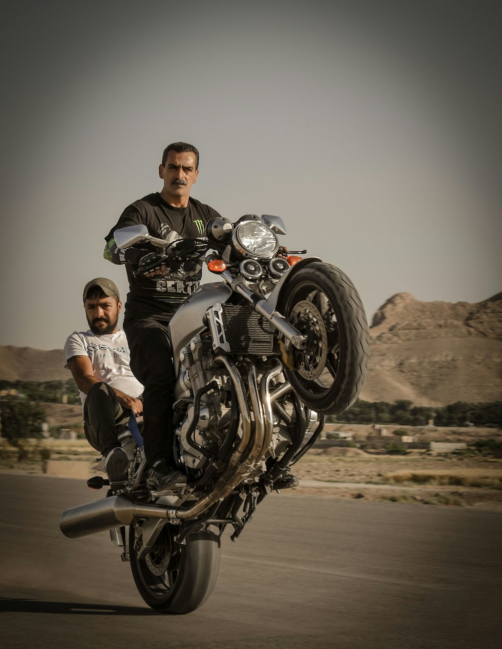 man in black jacket and woman in white shirt riding on black motorcycle during daytime