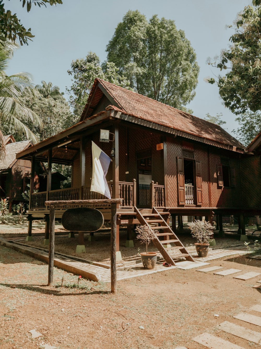 brown wooden house near green trees during daytime