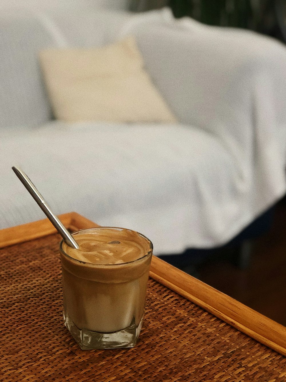 clear drinking glass with brown liquid on brown wooden table