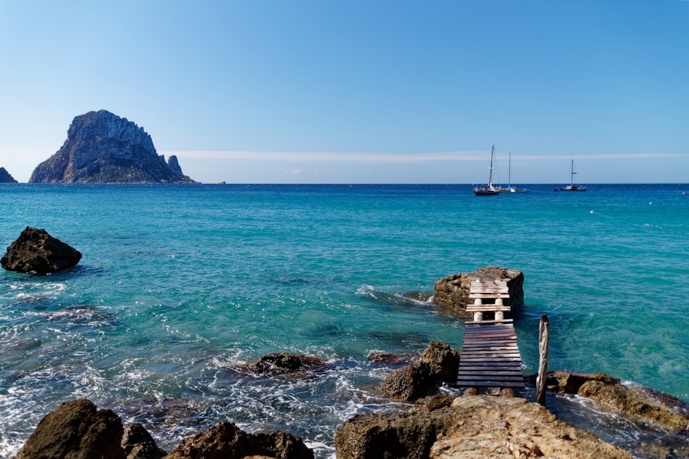 brown wooden dock on blue sea under blue sky during daytime