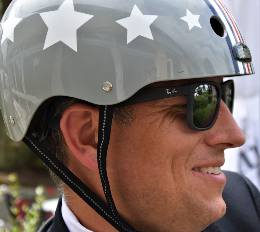 Hombre con gafas de sol negras y casco con estampado de estrellas en blanco y negro