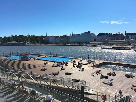 Community pool area with people enjoying the sun and nearby gym facilities.