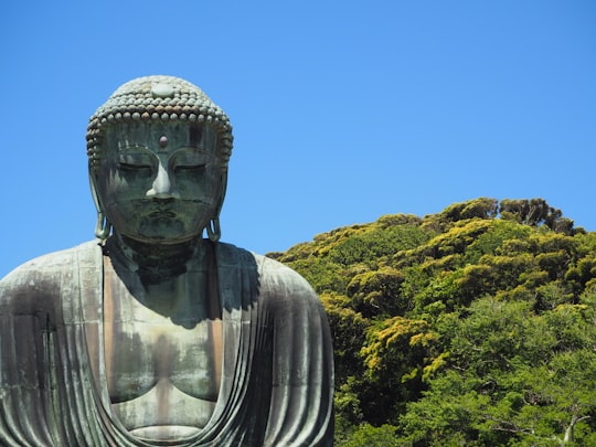 gray statue of man under blue sky during daytime in Kōtoku-in Japan