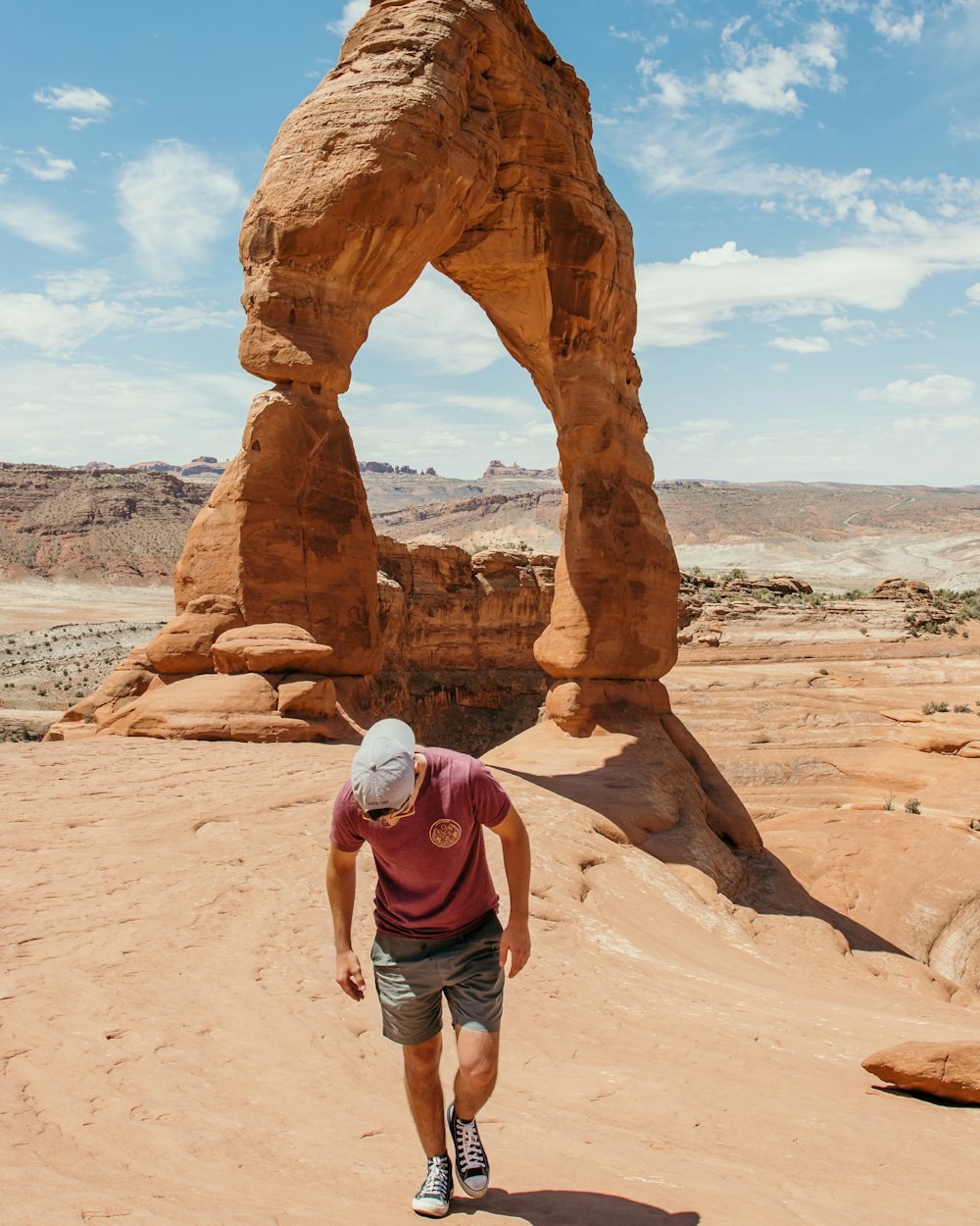 man in blue denim shorts and brown backpack standing on brown rock formation during daytime