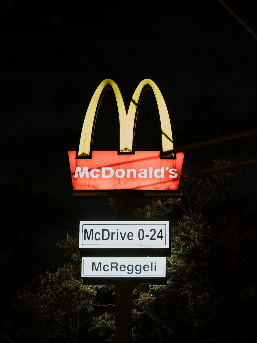 a mcdonald's sign is lit up at night