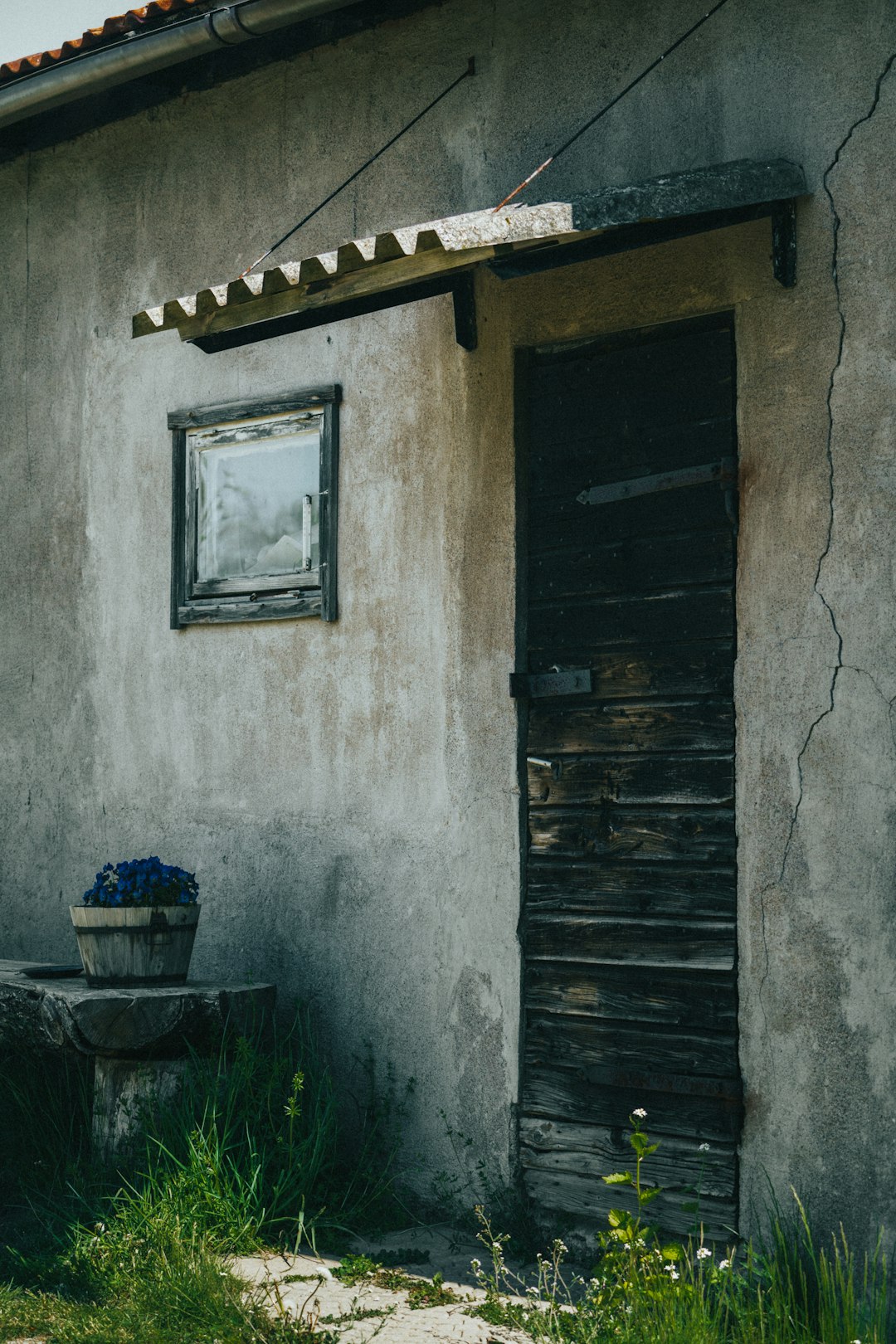 blue plastic bucket beside brown wooden door