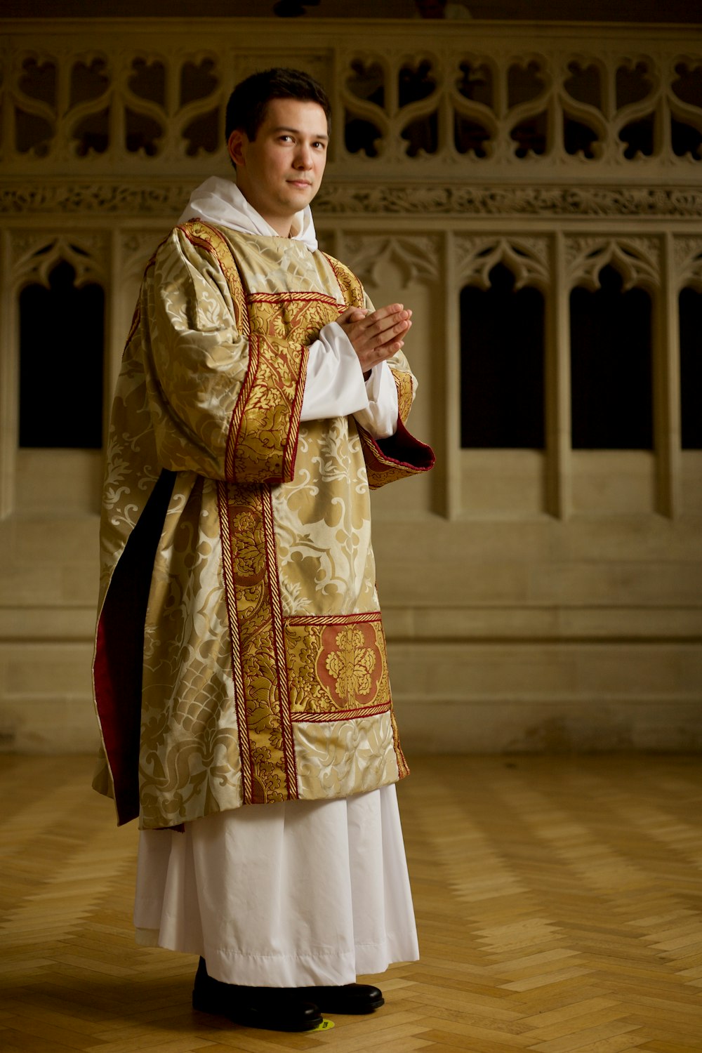 man in white and red thobe standing on brown wooden floor