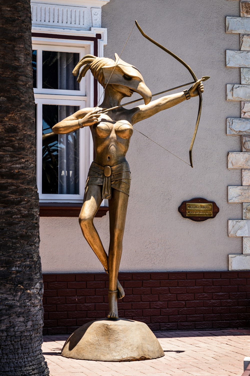 brown wooden statue on brown brick wall