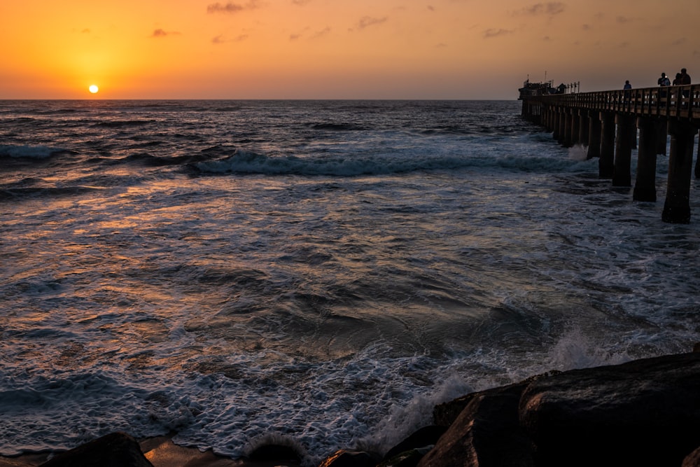 sea waves crashing on rocks during sunset