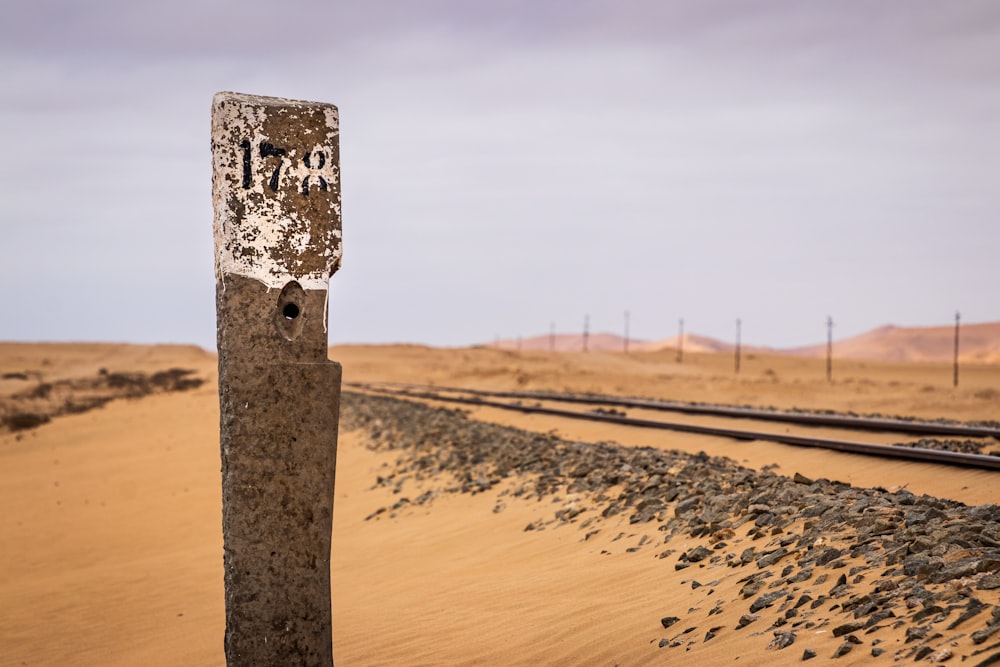 brown wooden post on brown sand during daytime