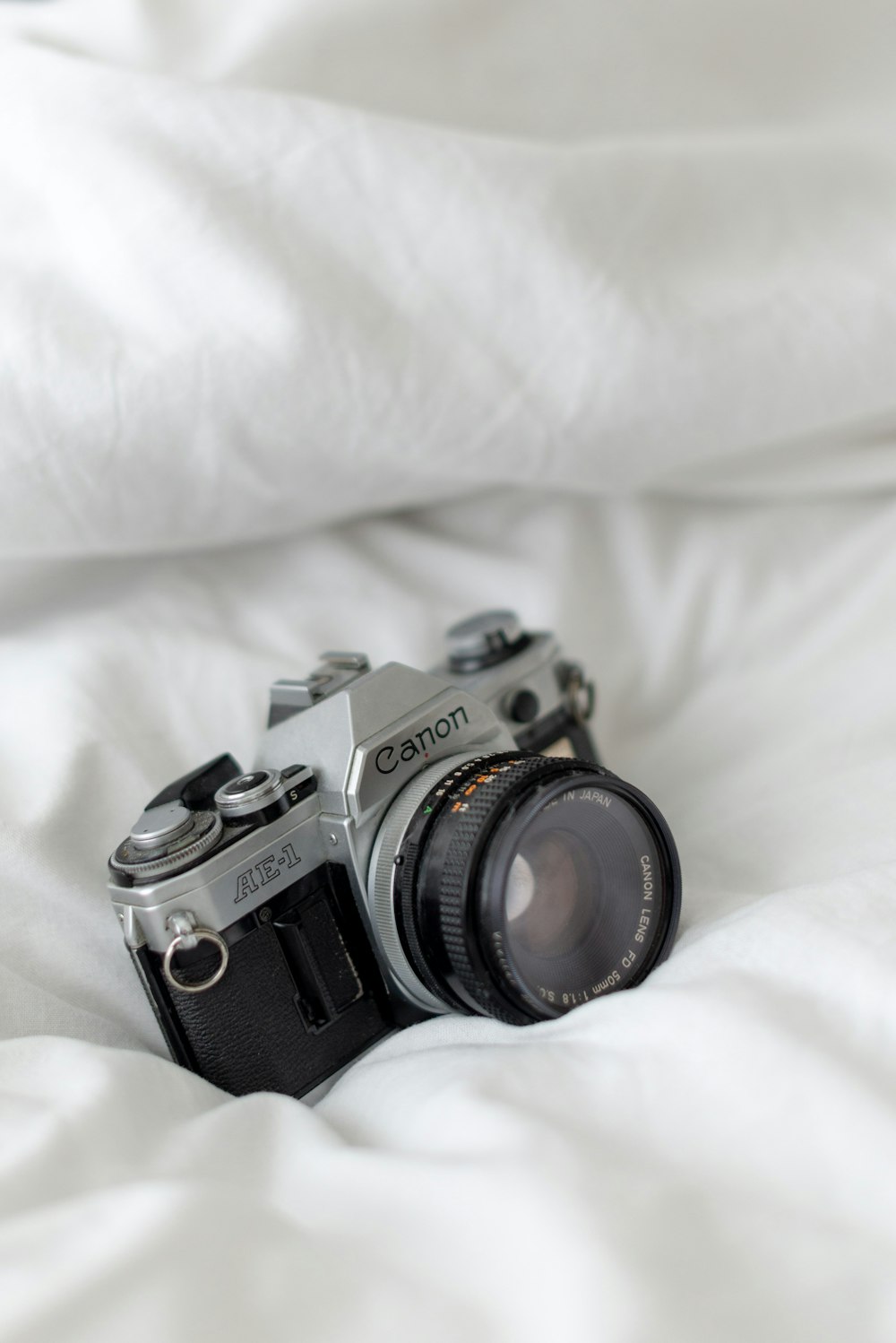 black and silver dslr camera on white textile