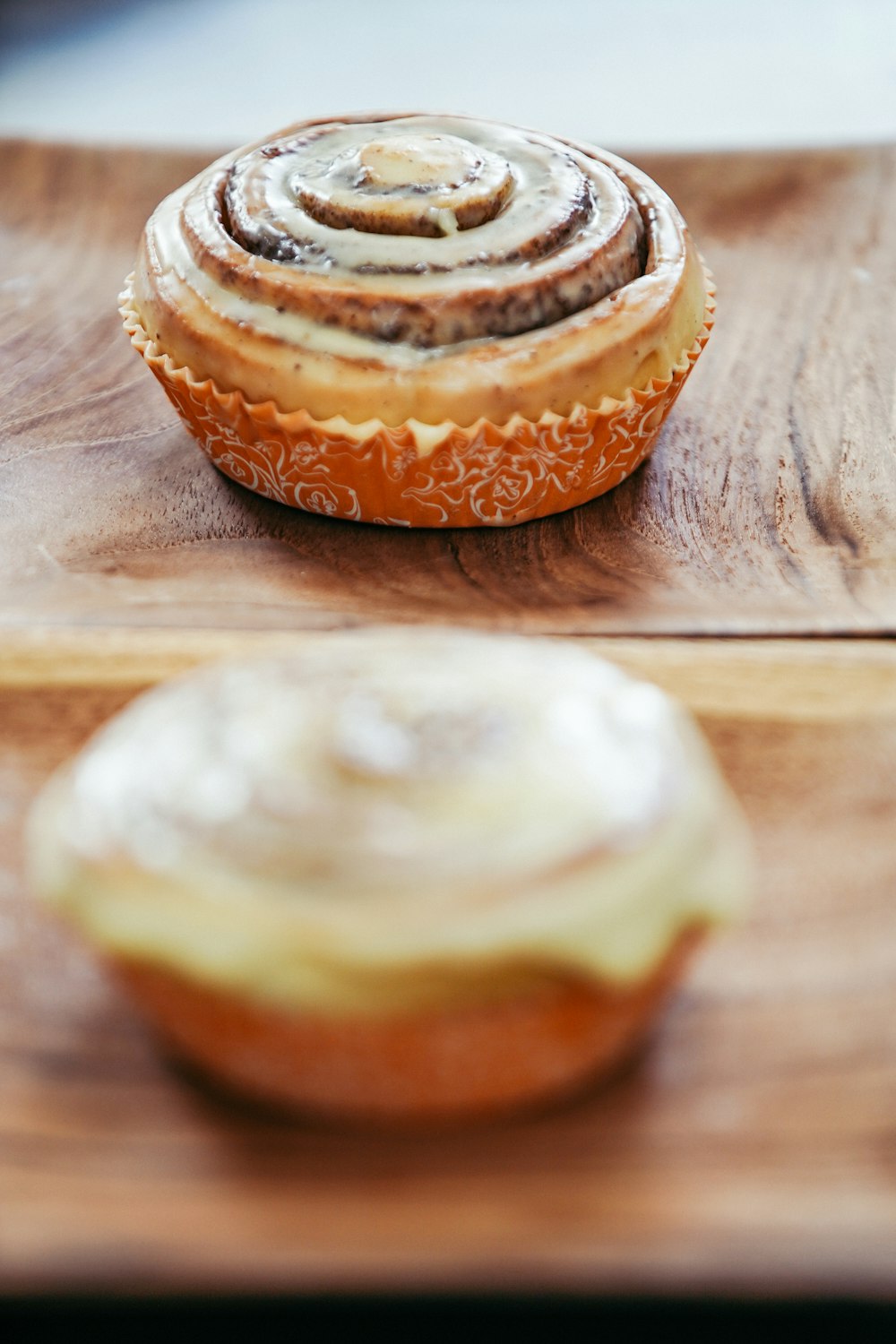 two cupcakes on brown wooden table