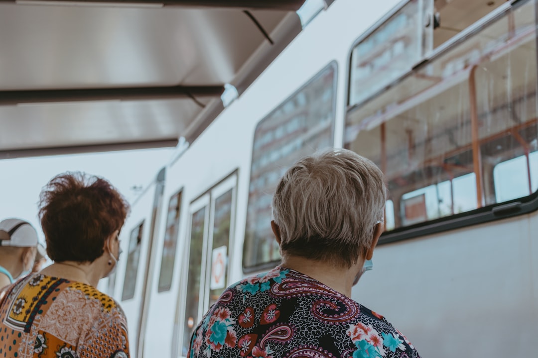 woman in blue and red floral shirt standing beside woman in white and blue floral shirt