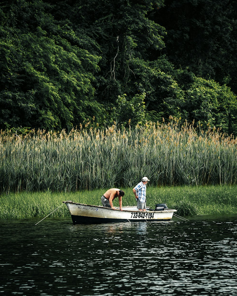 man in blue shirt riding on boat during daytime