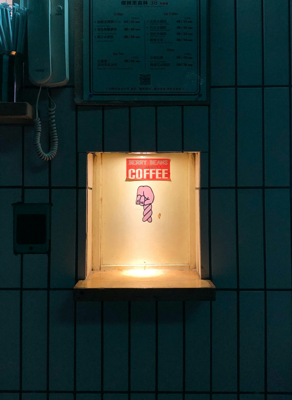 a lit up sign on the wall of a coffee shop