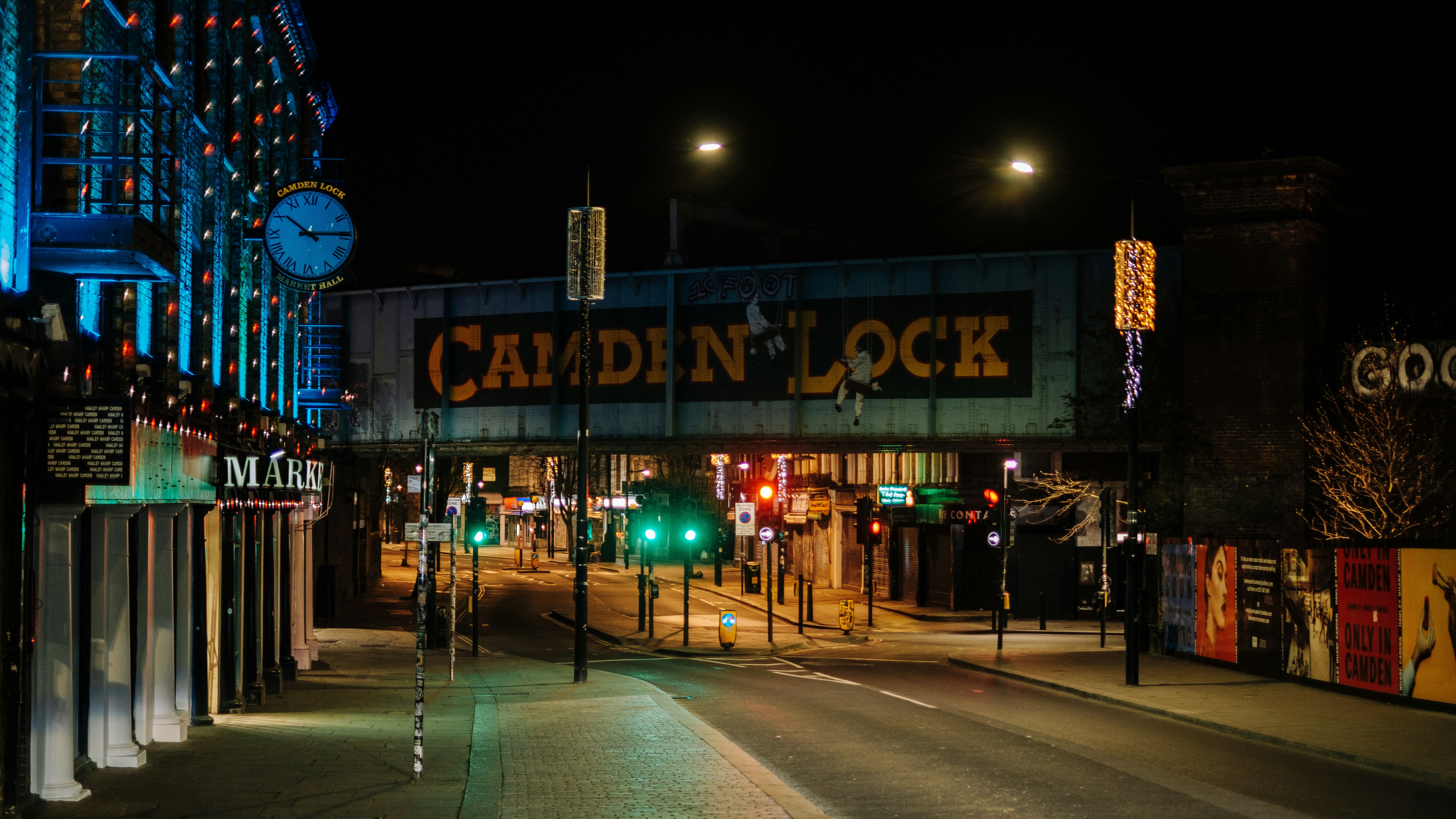 a city street at night with a clock tower in the background, Camden Lock Bridge