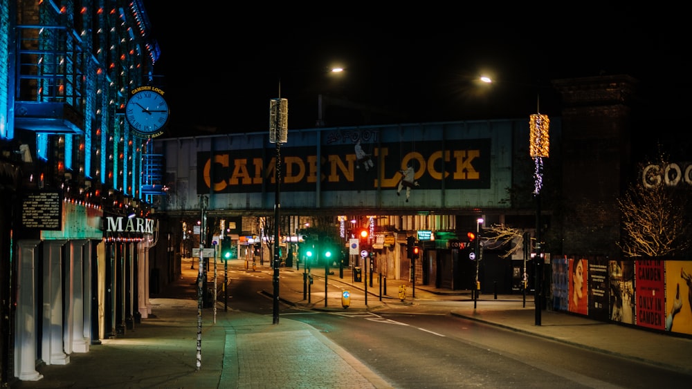 a city street at night with a clock tower in the background