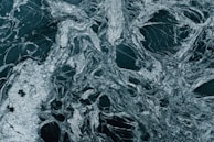 Close-up of polished stone surface showing intricate natural veining and glossy finish.