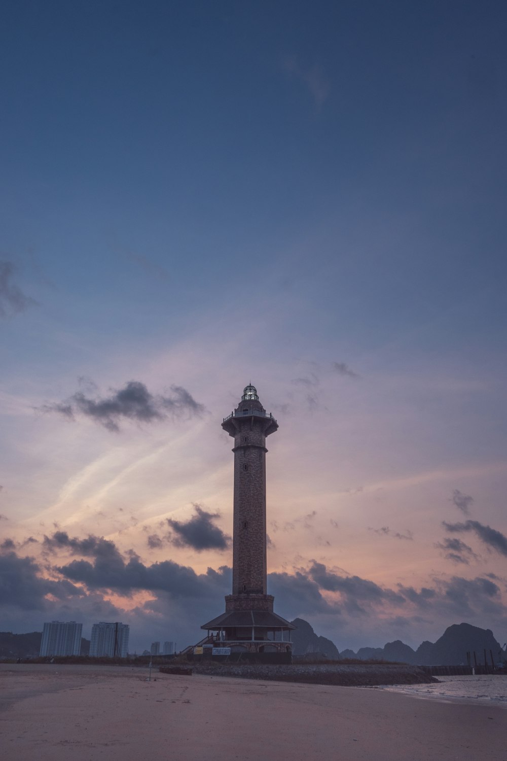 a tall tower sitting on top of a sandy beach