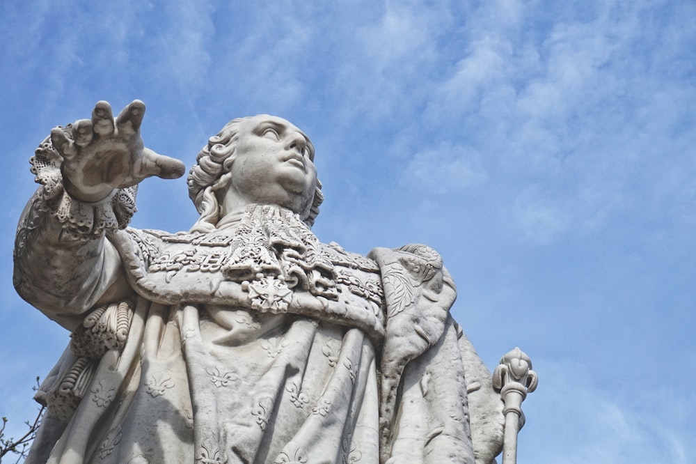 low angle photography of angel statue under blue sky during daytime