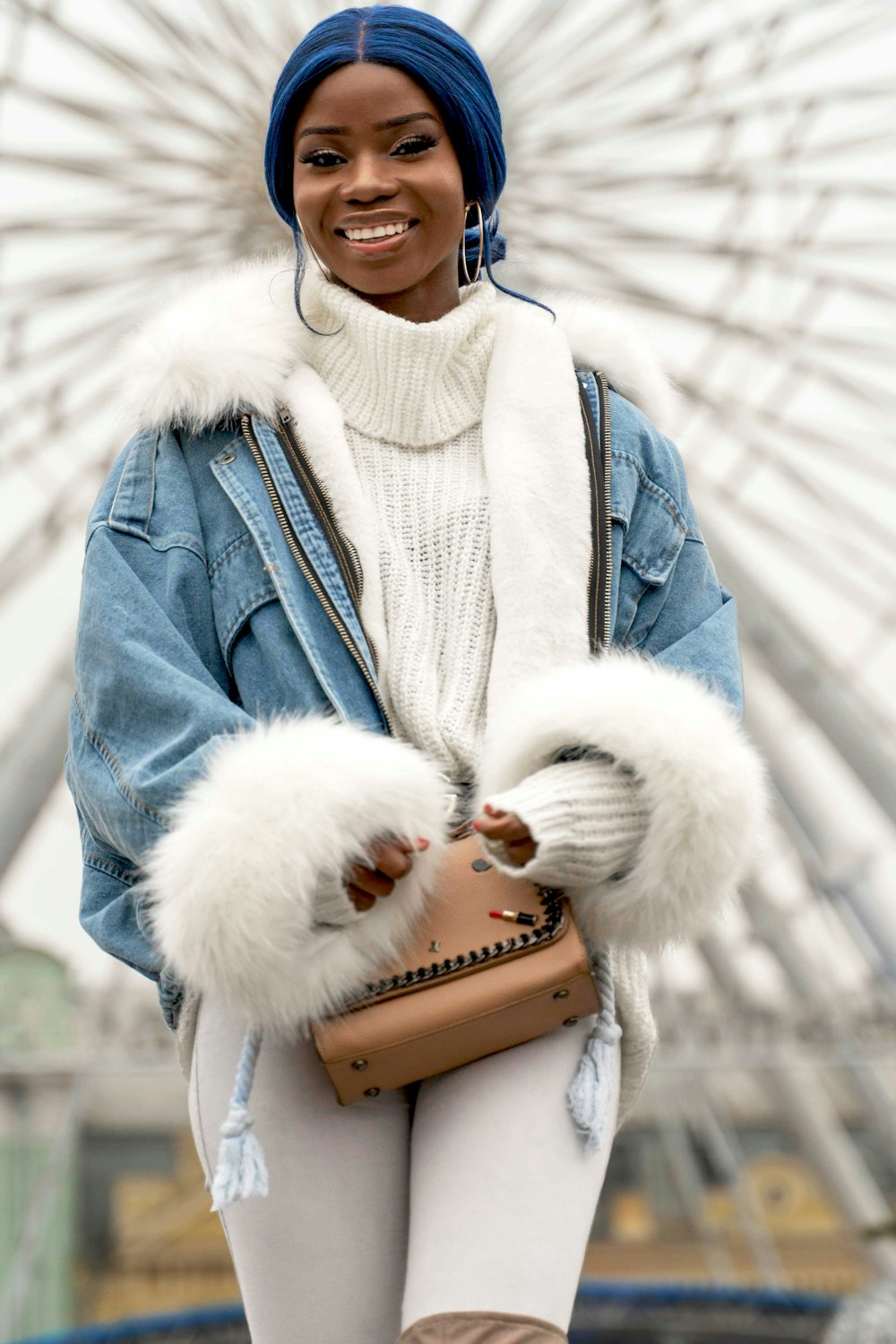 woman in blue denim jacket holding brown leather bag