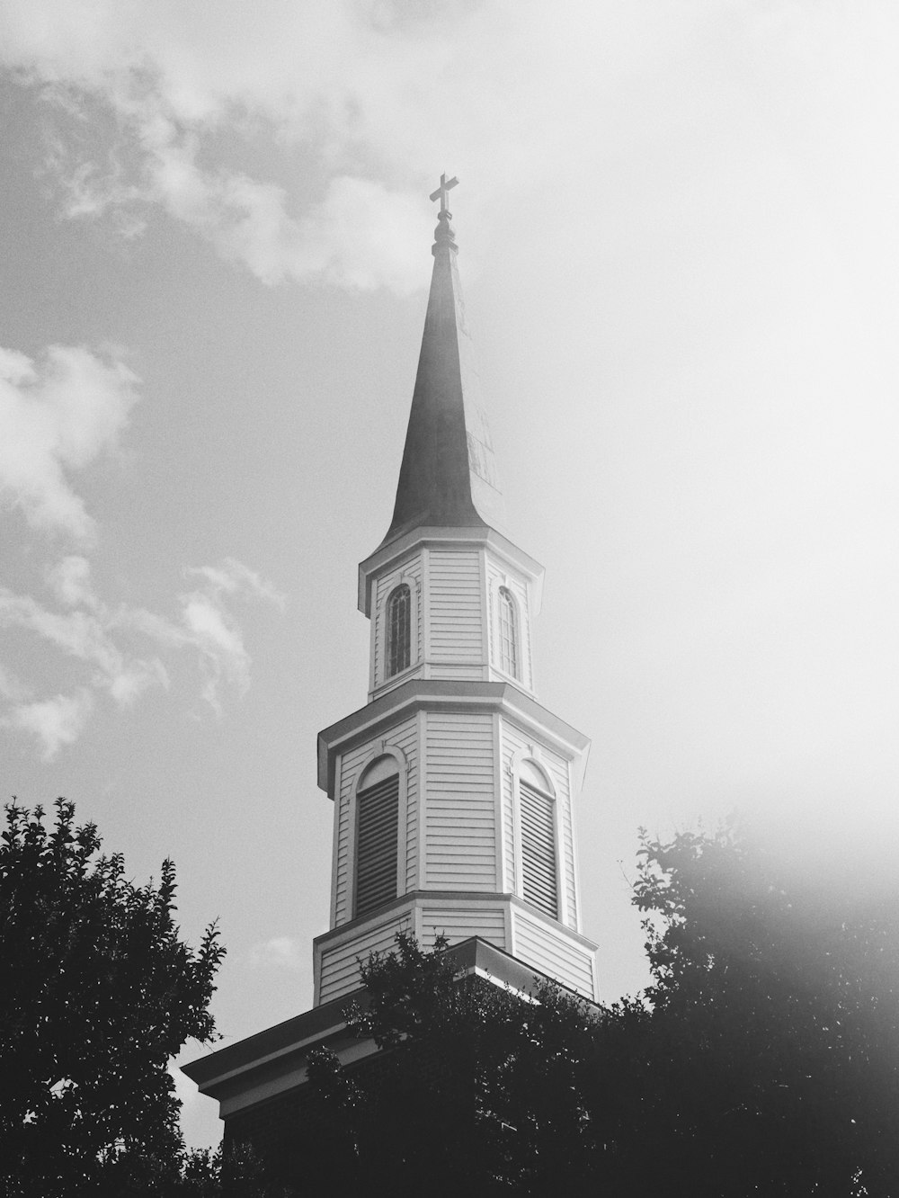 grayscale photo of church under cloudy sky