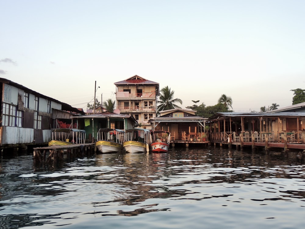 people on boat on river near houses during daytime